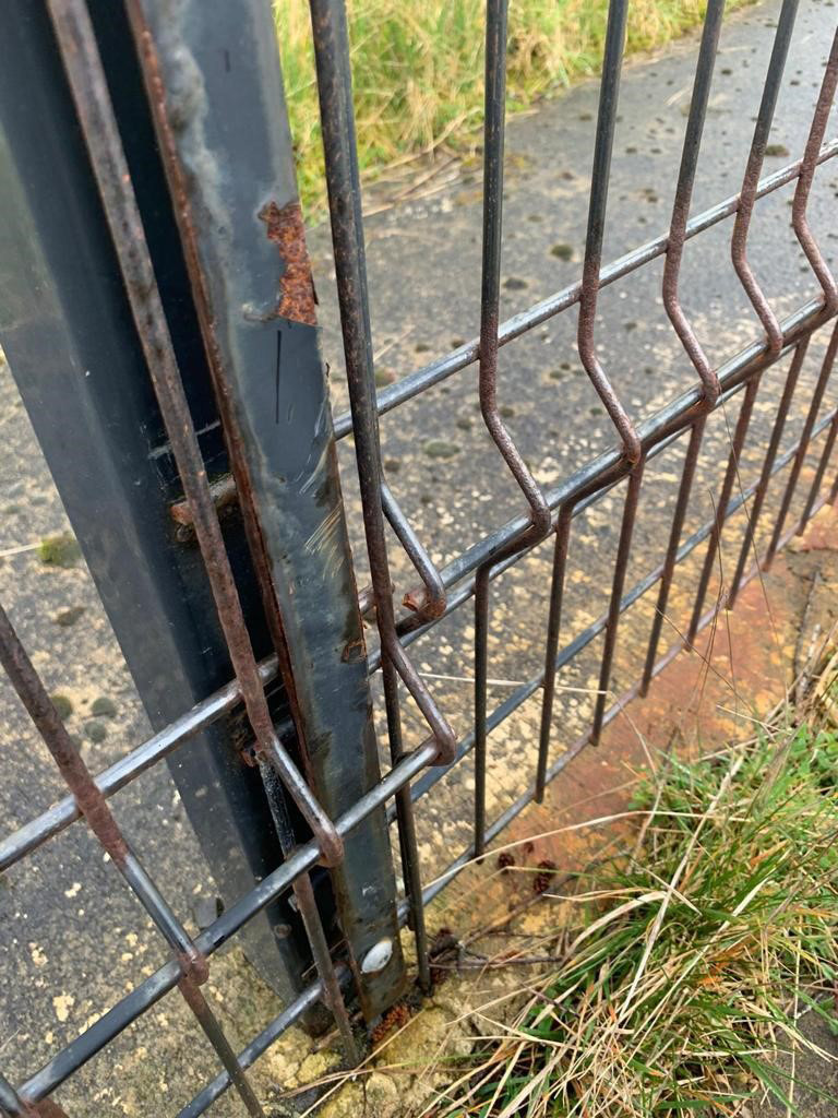 A generic v mesh security fence rusting.
