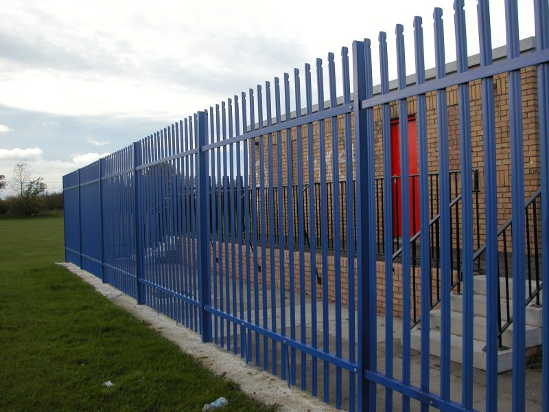 A blue Lochrin Classic™ palisade fence installed around a facility.