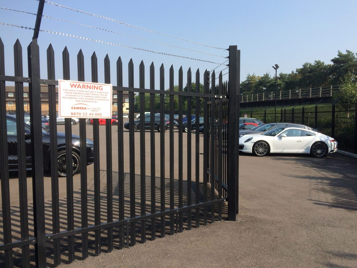 A black Lochrin Classic™ fence installed around a car dealership.